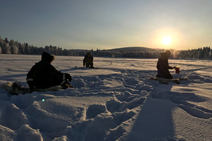 a group of people standing on top of a sandy beach covered in snow